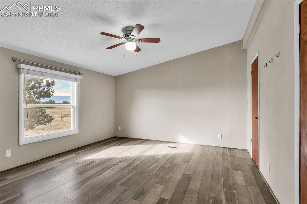 1044 P Street Penrose, CO 81240 - Photo 26 of 48 an empty room with wooden floor chandelier fan and windows