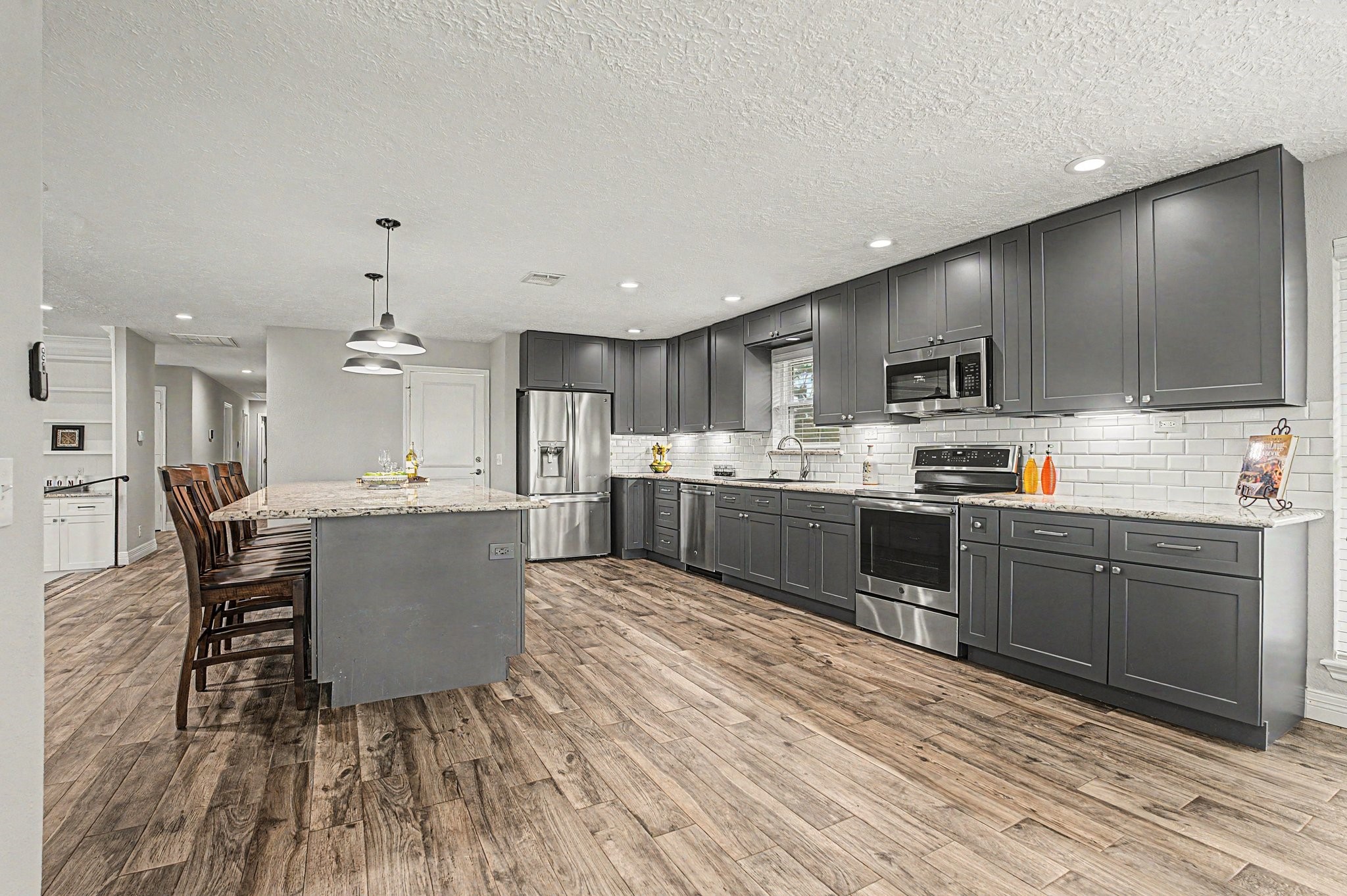 35564 Brumlow Road Hempstead, TX 77445 - Photo 10 of 46 a kitchen with stainless steel appliances kitchen island granite countertop a sink dishwasher a stove a kitchen island with chairs and wooden floor
