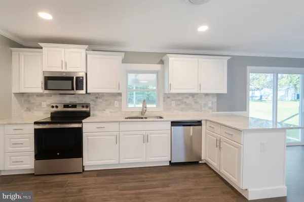 a kitchen with stainless steel appliances granite countertop a stove a sink and a microwave