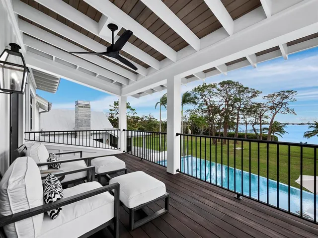 a front view of yellow house with a yard and potted plants