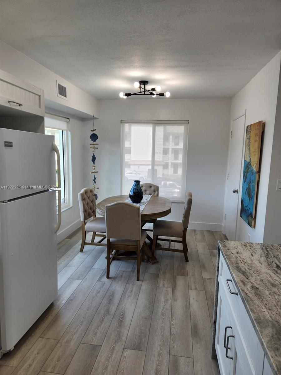 3320 Gulf Of Mexico Drive, Unit 208C Longboat Key, FL 34228 - Photo 13 of 39 a living room with furniture and a chandelier