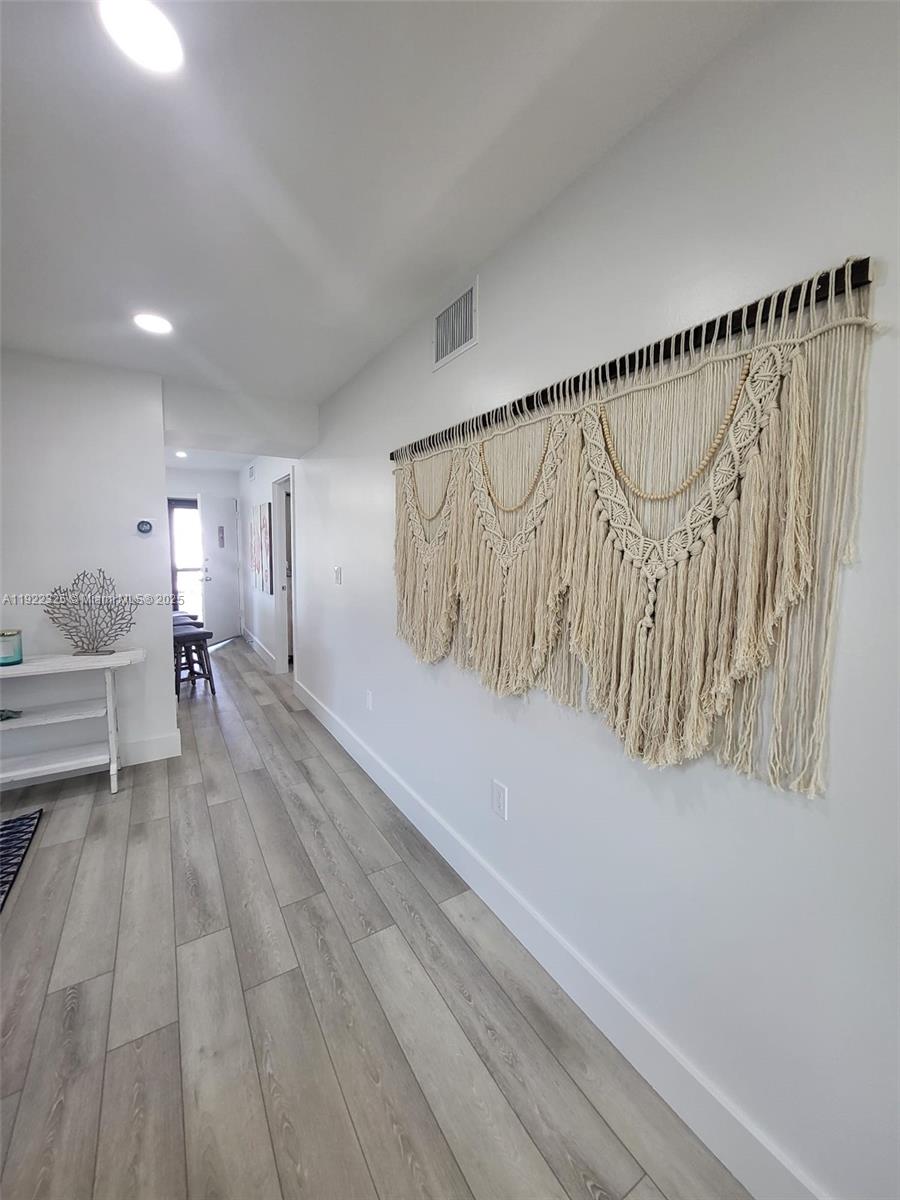 3320 Gulf Of Mexico Drive, Unit 208C Longboat Key, FL 34228 - Photo 16 of 39 a view of entryway and hall with wooden floor