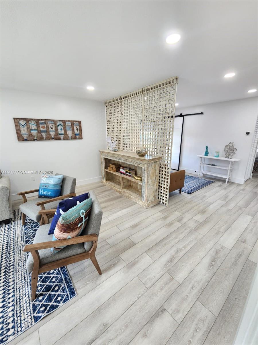 3320 Gulf Of Mexico Drive, Unit 208C Longboat Key, FL 34228 - Photo 20 of 39 a living room with furniture and a wooden floor