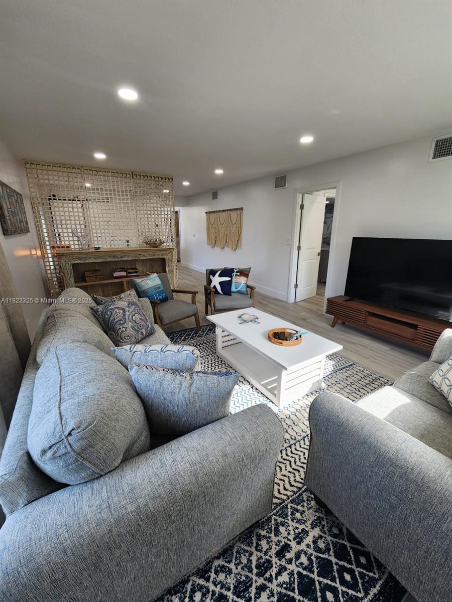 3320 Gulf Of Mexico Drive, Unit 208C Longboat Key, FL 34228 - Photo 24 of 39 a living room with furniture and a flat screen tv