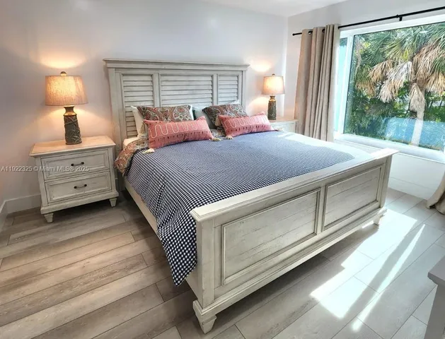 a bedroom with a bed and a large window