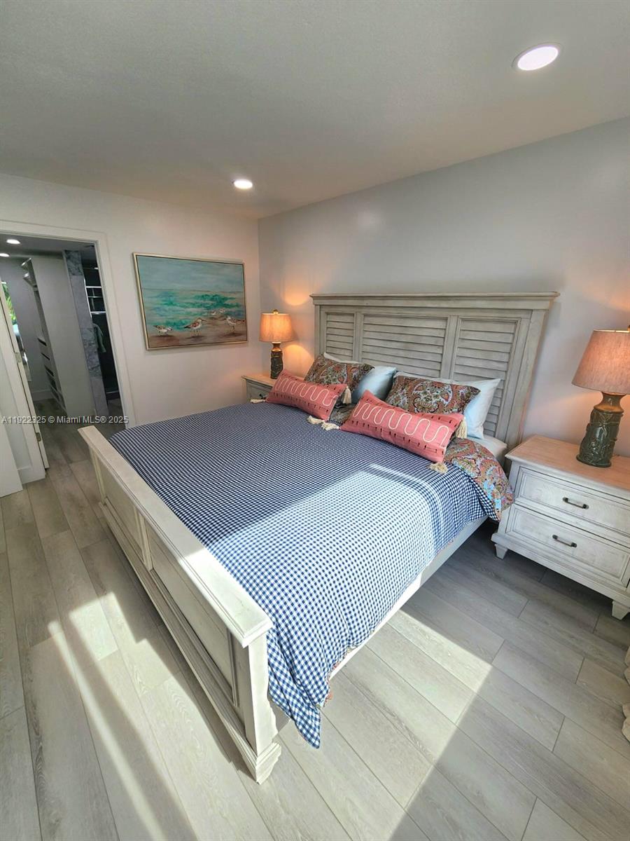 3320 Gulf Of Mexico Drive, Unit 208C Longboat Key, FL 34228 - Photo 26 of 39 a bedroom with a bed and a flat screen tv