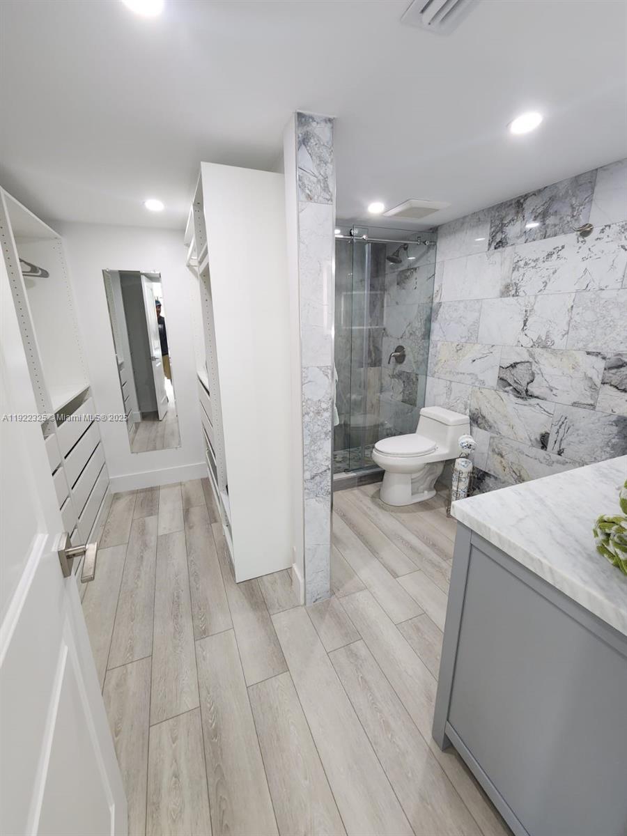 3320 Gulf Of Mexico Drive, Unit 208C Longboat Key, FL 34228 - Photo 28 of 39 a bathroom with a sink a toilet and a large mirror