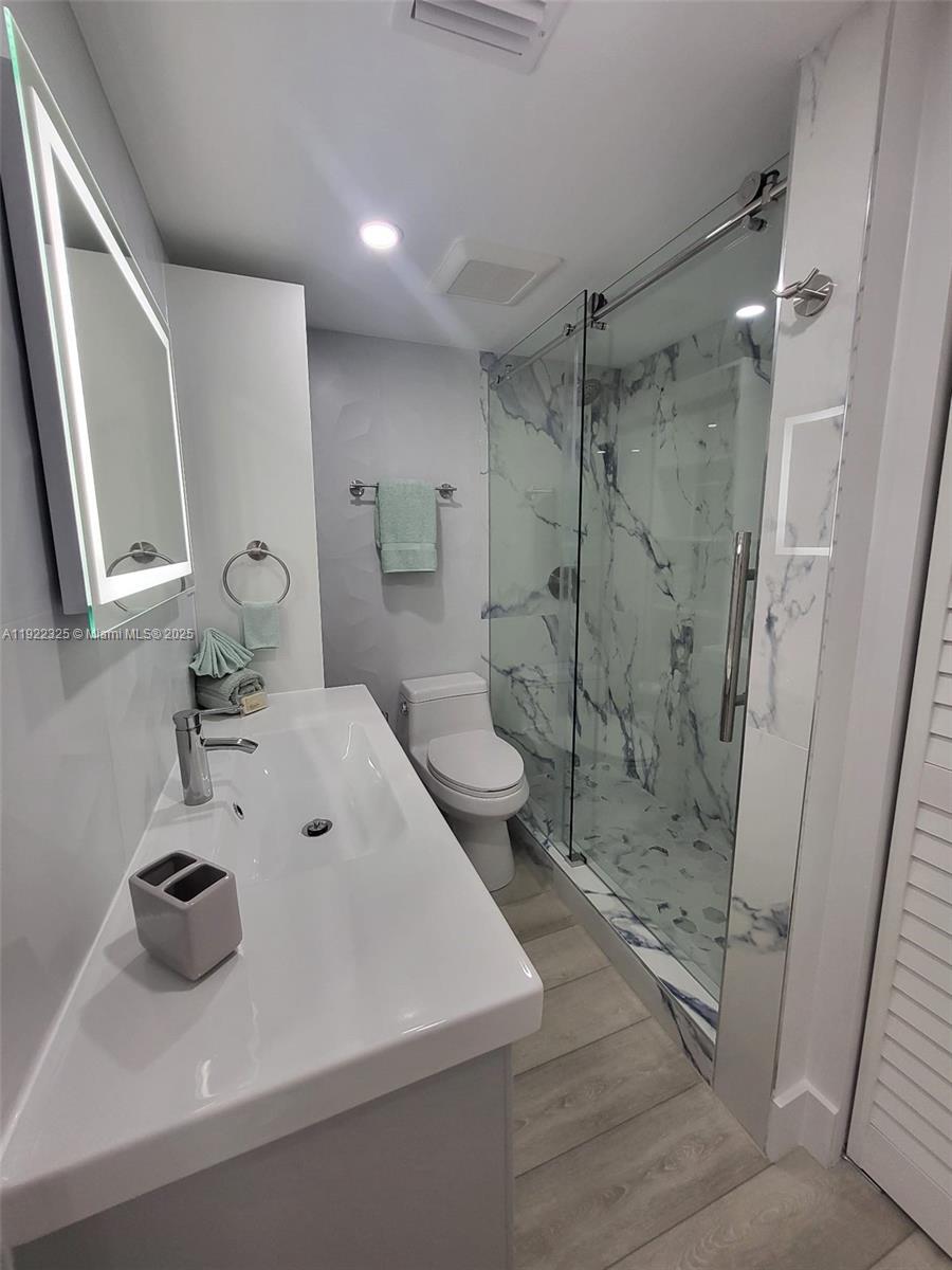 3320 Gulf Of Mexico Drive, Unit 208C Longboat Key, FL 34228 - Photo 31 of 39 a bathroom with a sink toilet and shower