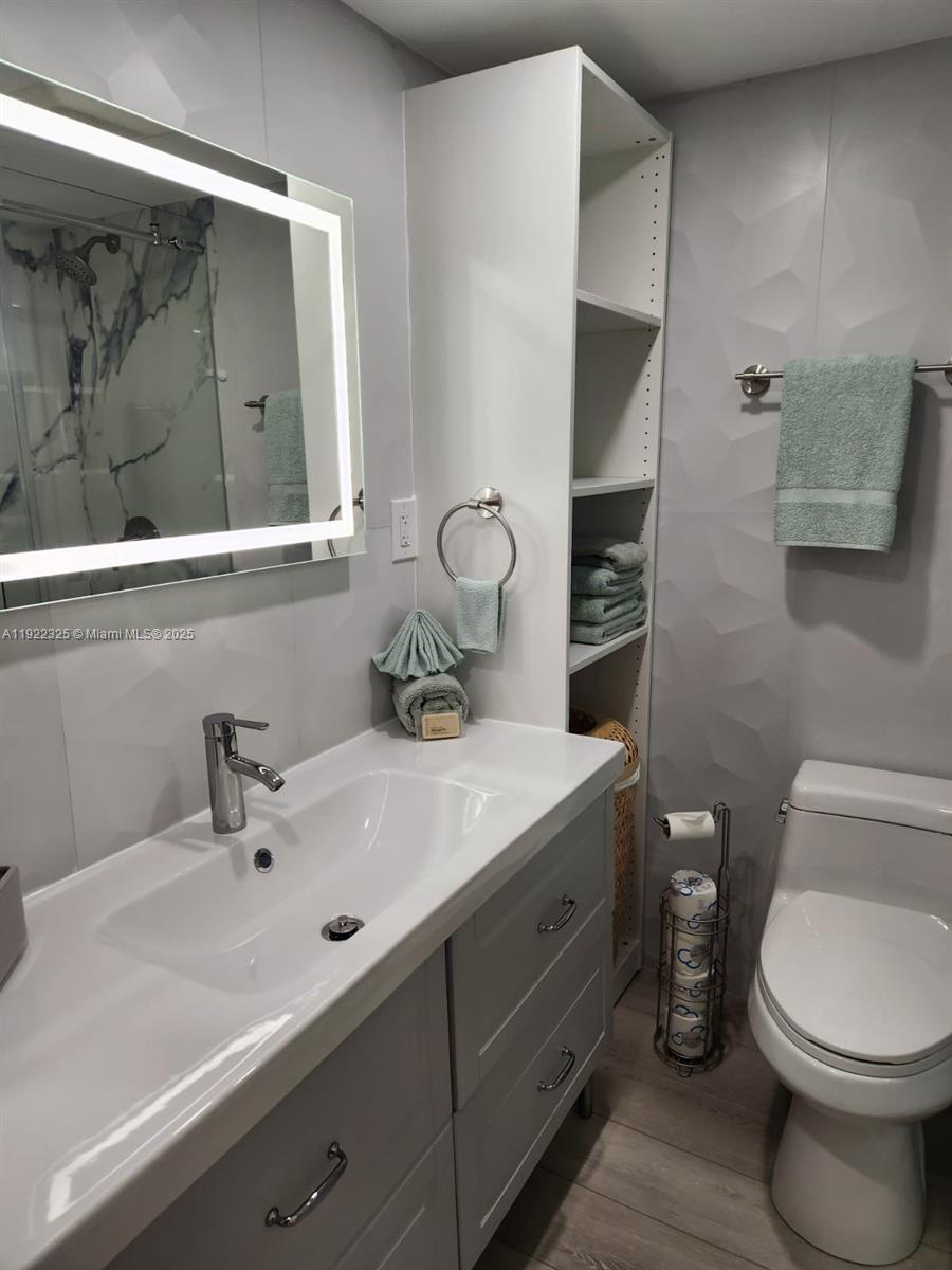 3320 Gulf Of Mexico Drive, Unit 208C Longboat Key, FL 34228 - Photo 32 of 39 a bathroom with a toilet a sink and mirror
