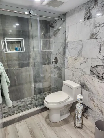 a bathroom with a toilet and a shower