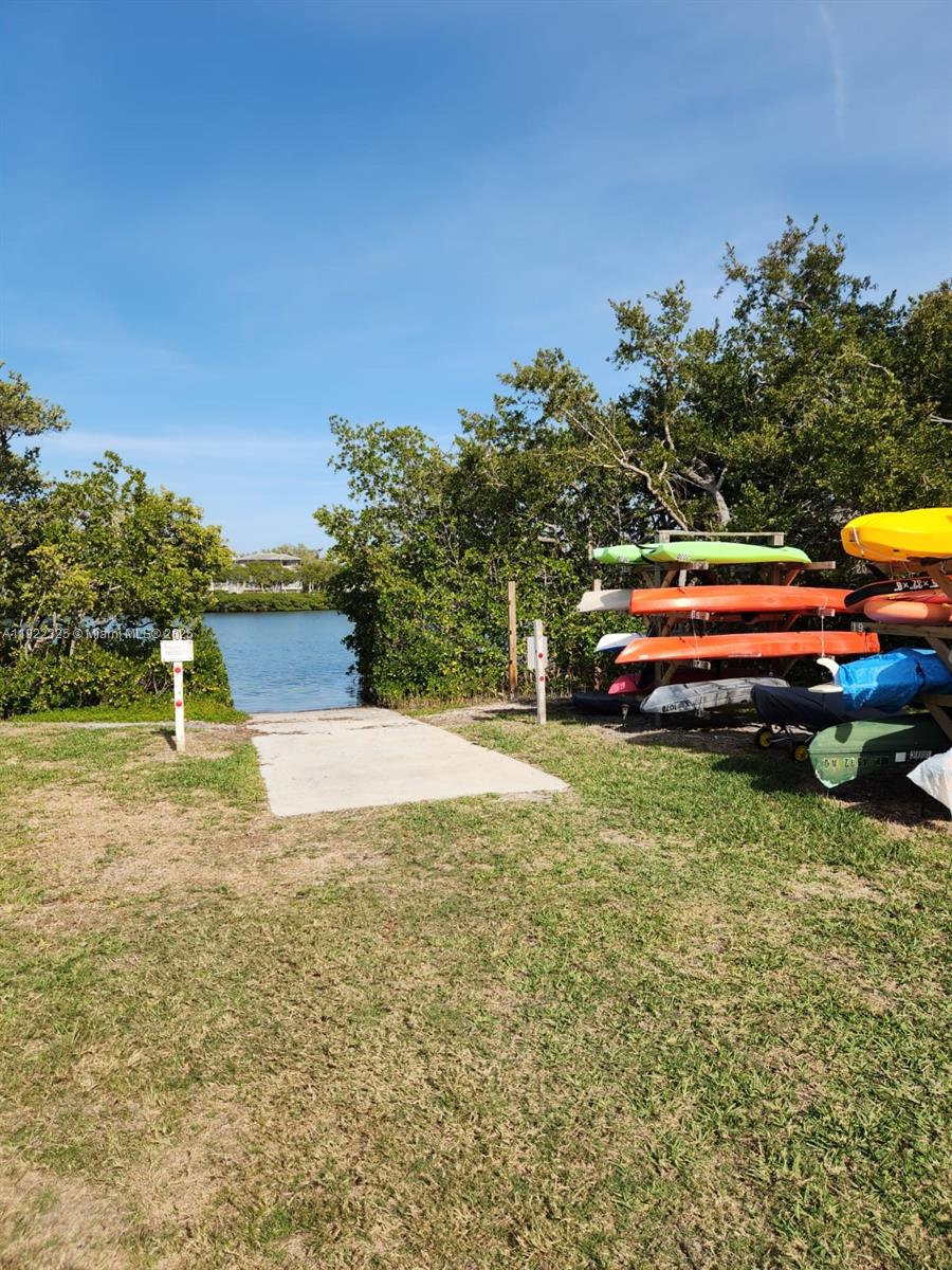 3320 Gulf Of Mexico Drive, Unit 208C Longboat Key, FL 34228 - Photo 39 of 39 a yellow swimming pool is sitting in the backyard of house