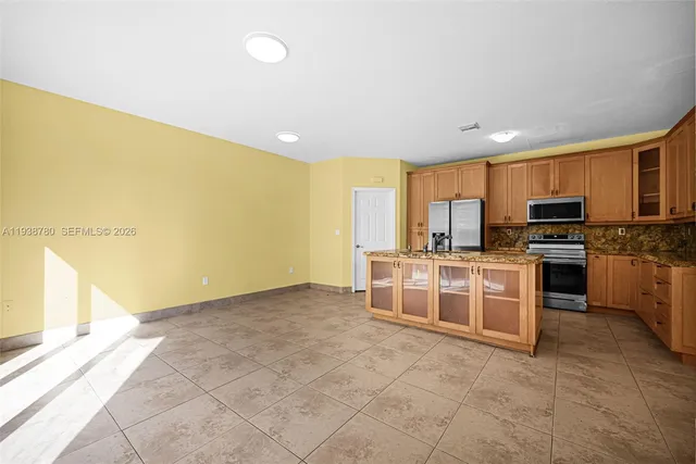 a kitchen with granite countertop a stove top oven a sink a counter top space and cabinets