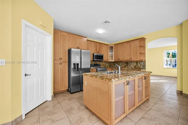 a kitchen with a stove top oven and refrigerator