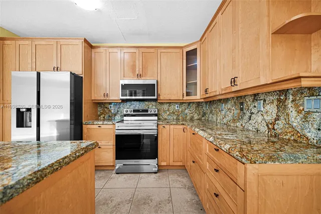 a kitchen with stainless steel appliances granite countertop a stove a sink and a microwave