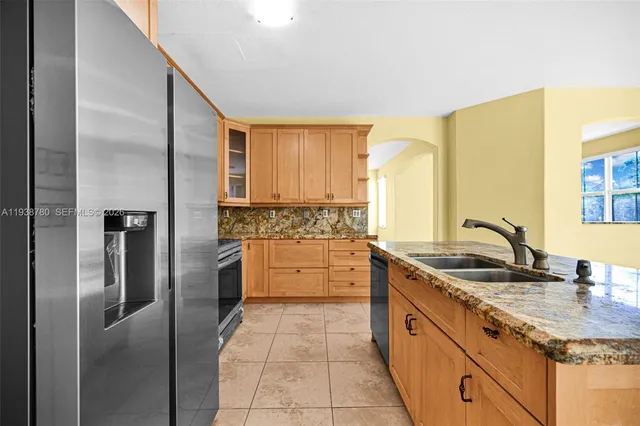 a kitchen with granite countertop a sink stainless steel appliances and cabinets