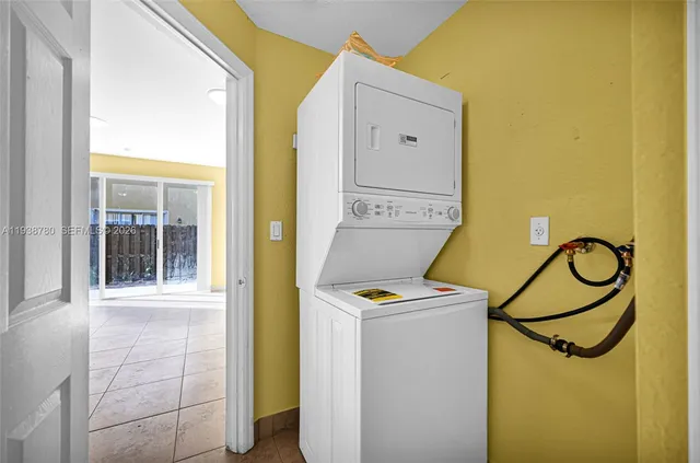 a view of a room with gym equipment and a chandelier
