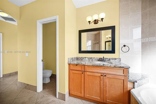 a bathroom with a granite countertop sink a mirror and a shower