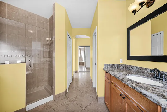 a bathroom with a granite countertop toilet a sink and a mirror