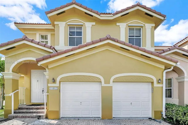 a front view of a house with a garden