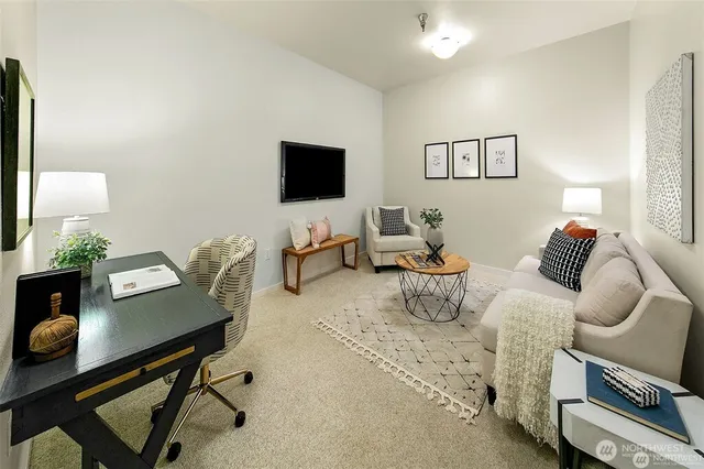 a living room with furniture a flat screen tv and a window