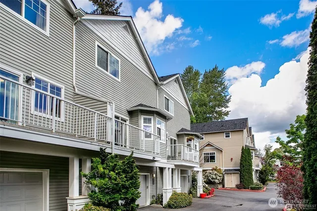 a view of a white building among the street with palm trees