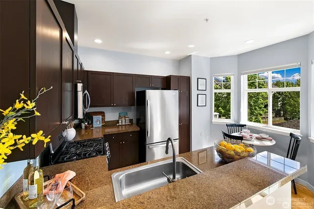 a kitchen with stainless steel appliances granite countertop a refrigerator and a sink