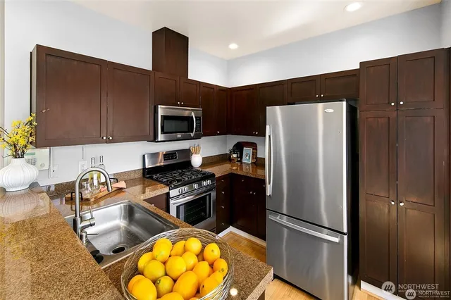 a kitchen with a refrigerator and a stove top oven