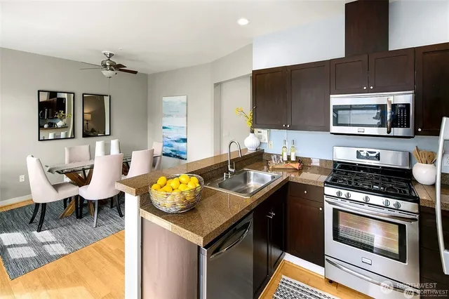 a kitchen with stainless steel appliances granite countertop a sink stove and microwave