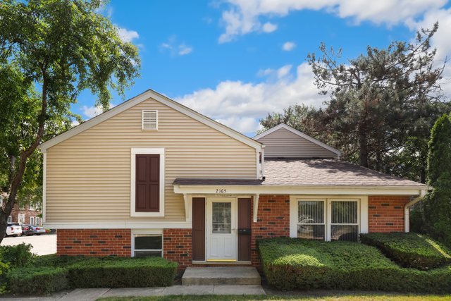 a view of a white house next to a yard