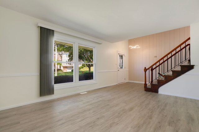 2105 Sutherland Place Hoffman Estates, IL 60169 - Photo 3 of 27 a view of an empty room with wooden floor and a window