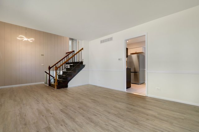 2105 Sutherland Place Hoffman Estates, IL 60169 - Photo 4 of 27 a view of an empty room with wooden floor and stairs
