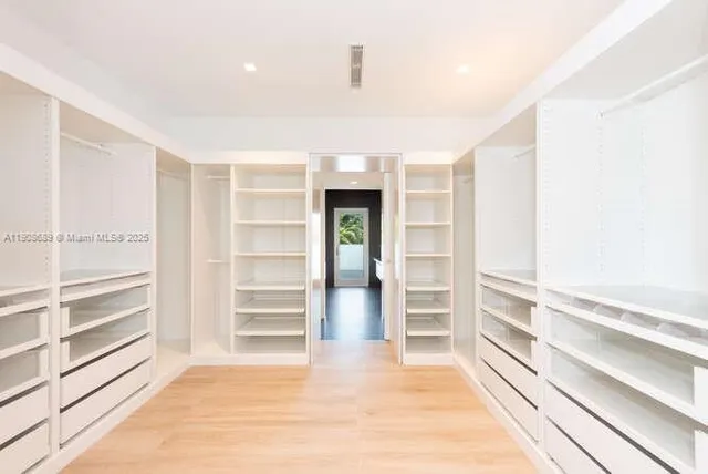 a view of a yard with plants and wooden fence