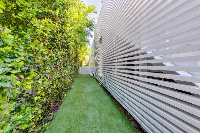 1325 Bay Drive Miami Beach, FL 33141 - Photo 49 of 49 a view of a yard with plants and wooden fence