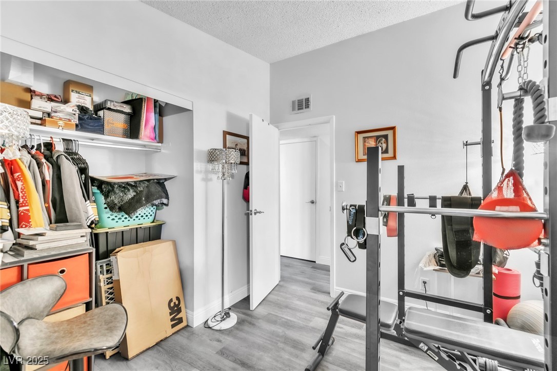 111 Maple Street Henderson, NV 89015 - Photo 11 of 37 Exercise room featuring a textured ceiling and wood finished floors