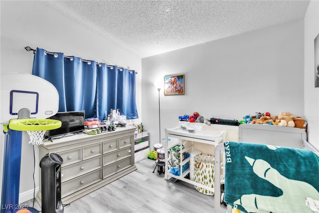 111 Maple Street Henderson, NV 89015 - Photo 18 of 37 Bedroom with a textured ceiling and wood finished floors