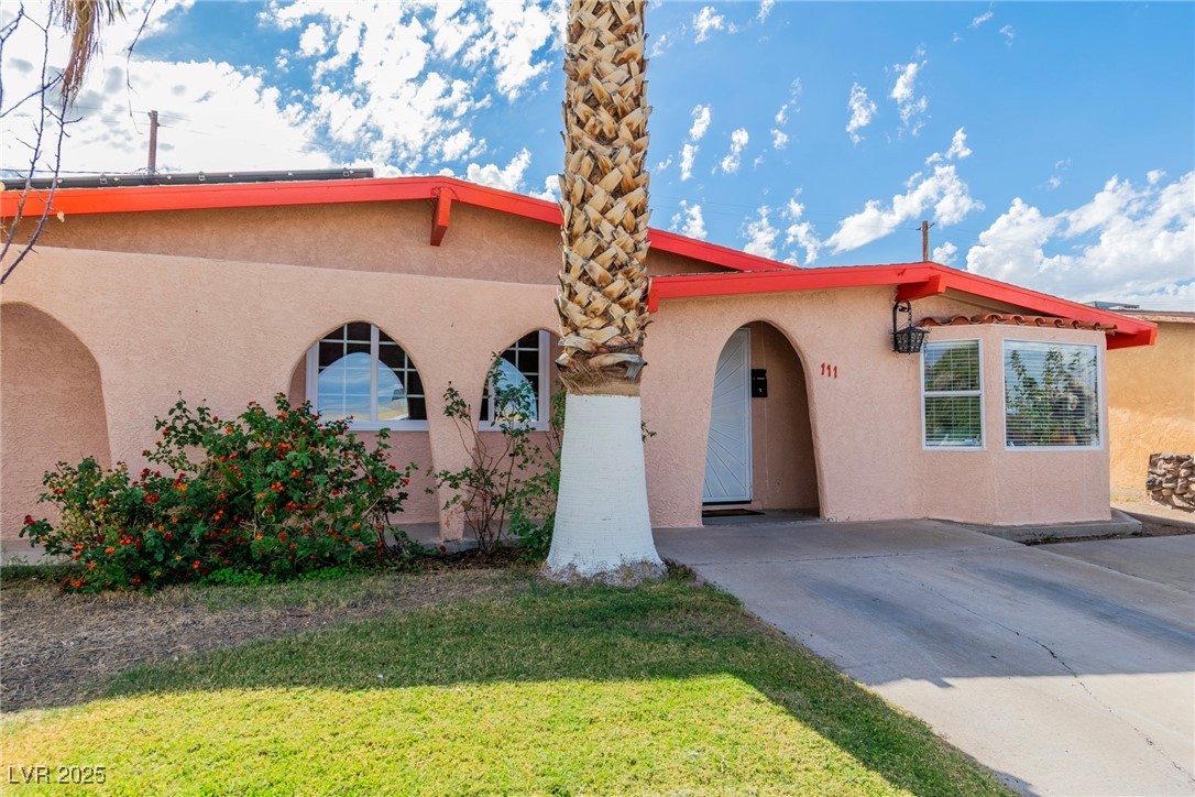 111 Maple Street Henderson, NV 89015 - Photo 2 of 37 View of front facade featuring stucco siding, a front lawn, and driveway
