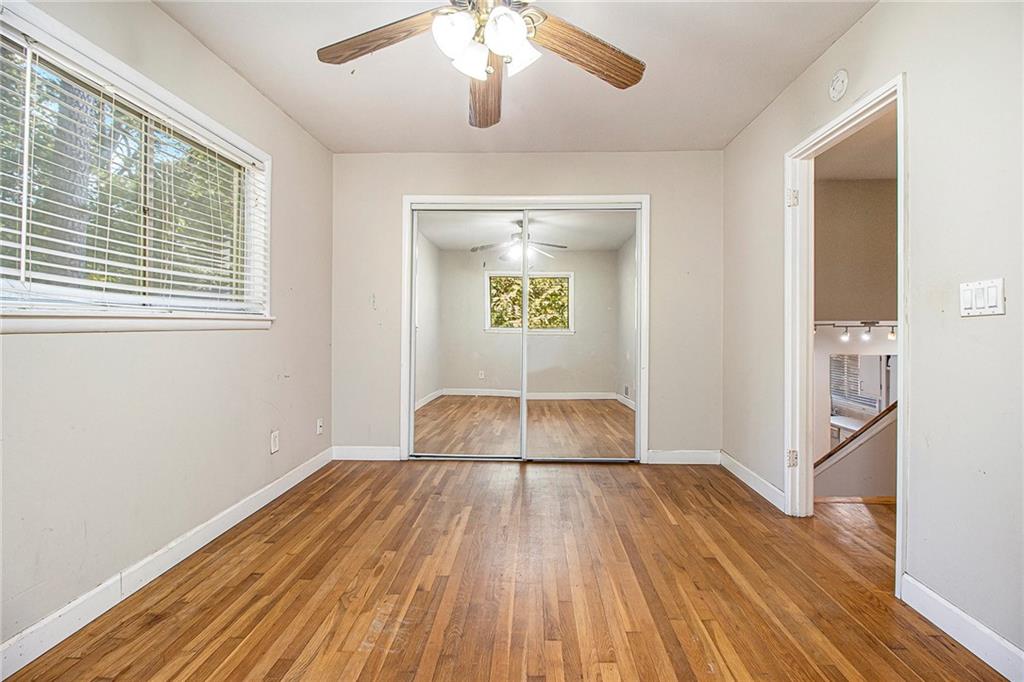 1961 Kenwood Road Southeast Smyrna, GA 30082 - Photo 13 of 33 a view of a room with wooden floor a ceiling fan and windows