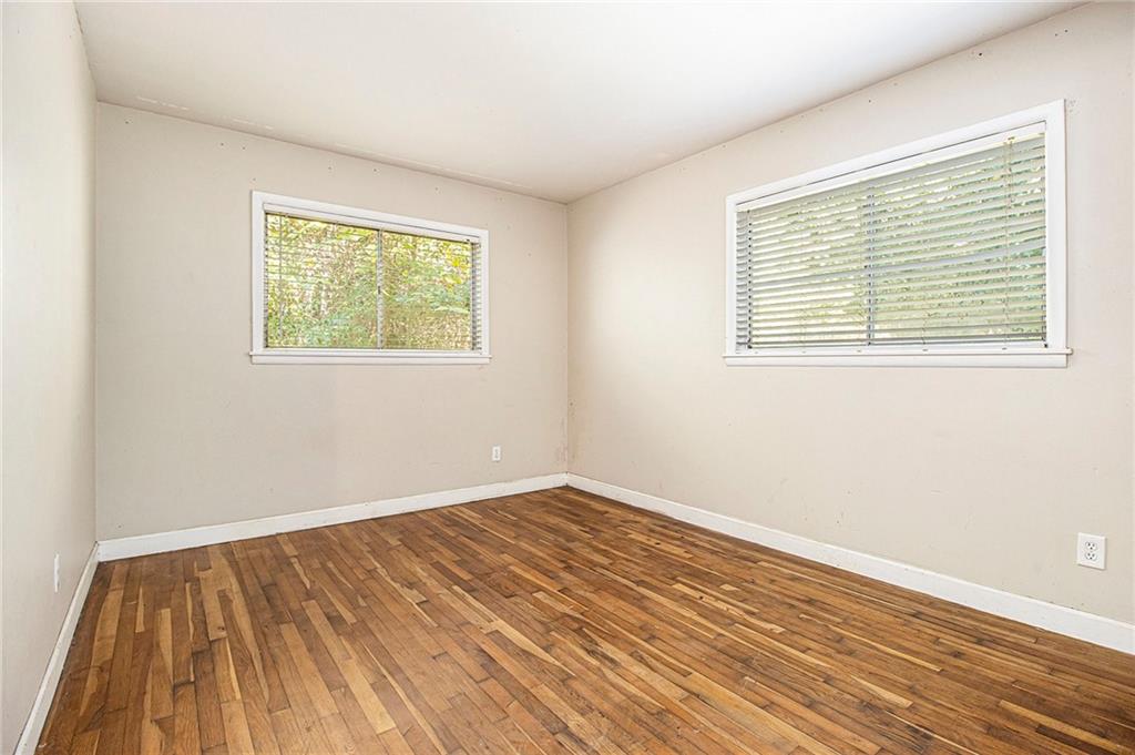 1961 Kenwood Road Southeast Smyrna, GA 30082 - Photo 19 of 33 a view of an empty room with wooden floor and a window