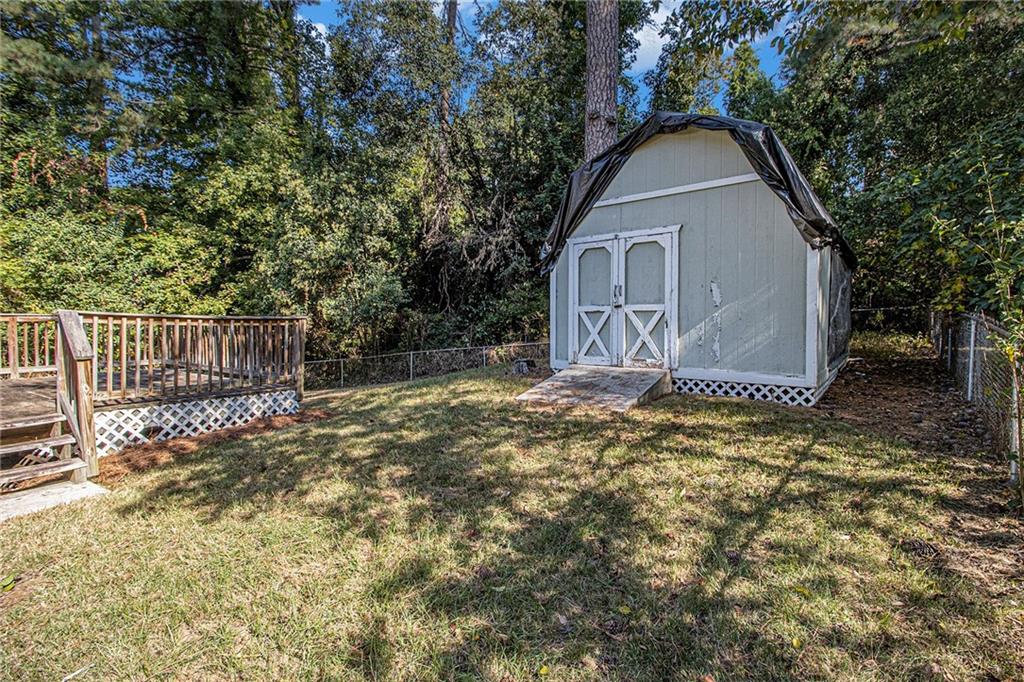 1961 Kenwood Road Southeast Smyrna, GA 30082 - Photo 32 of 33 a view of a wooden house with large trees and wooden fence