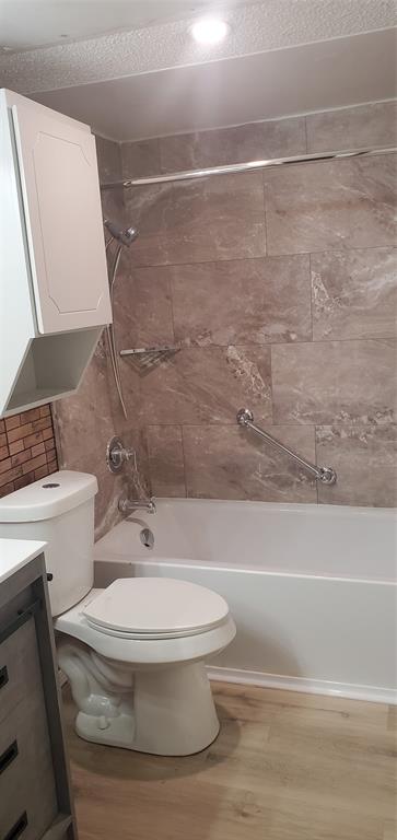 5532 Boca Raton Boulevard, Unit 290 Fort Worth, TX 76112 - Photo 5 of 16 Newly updated, Bathroom featuring a white bathtub, beige-toned wall tile, a chrome shower fixture, and a white toilet