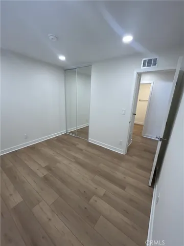 a view of kitchen with refrigerator stove and wooden floor