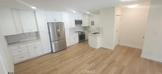 a kitchen with white cabinets and stainless steel appliances