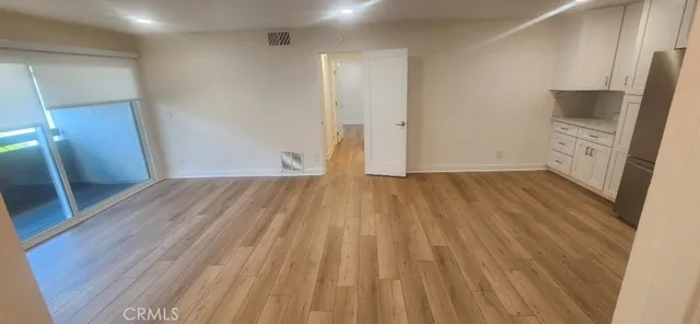 a view of a room with wooden floor and a window