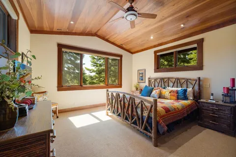 a bed sitting in a spacious bedroom next to a window