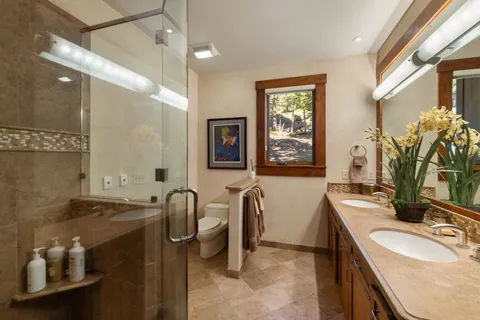 a spacious bathroom with a double vanity sink a mirror and a bathtub