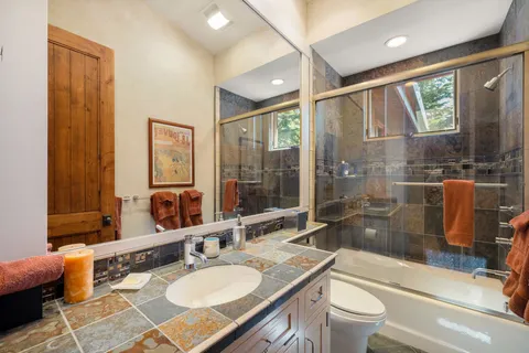 a bathroom with a shower sink vanity mirror and toilet