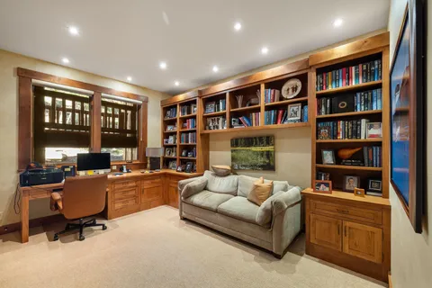 a living room with fireplace furniture and a book shelf