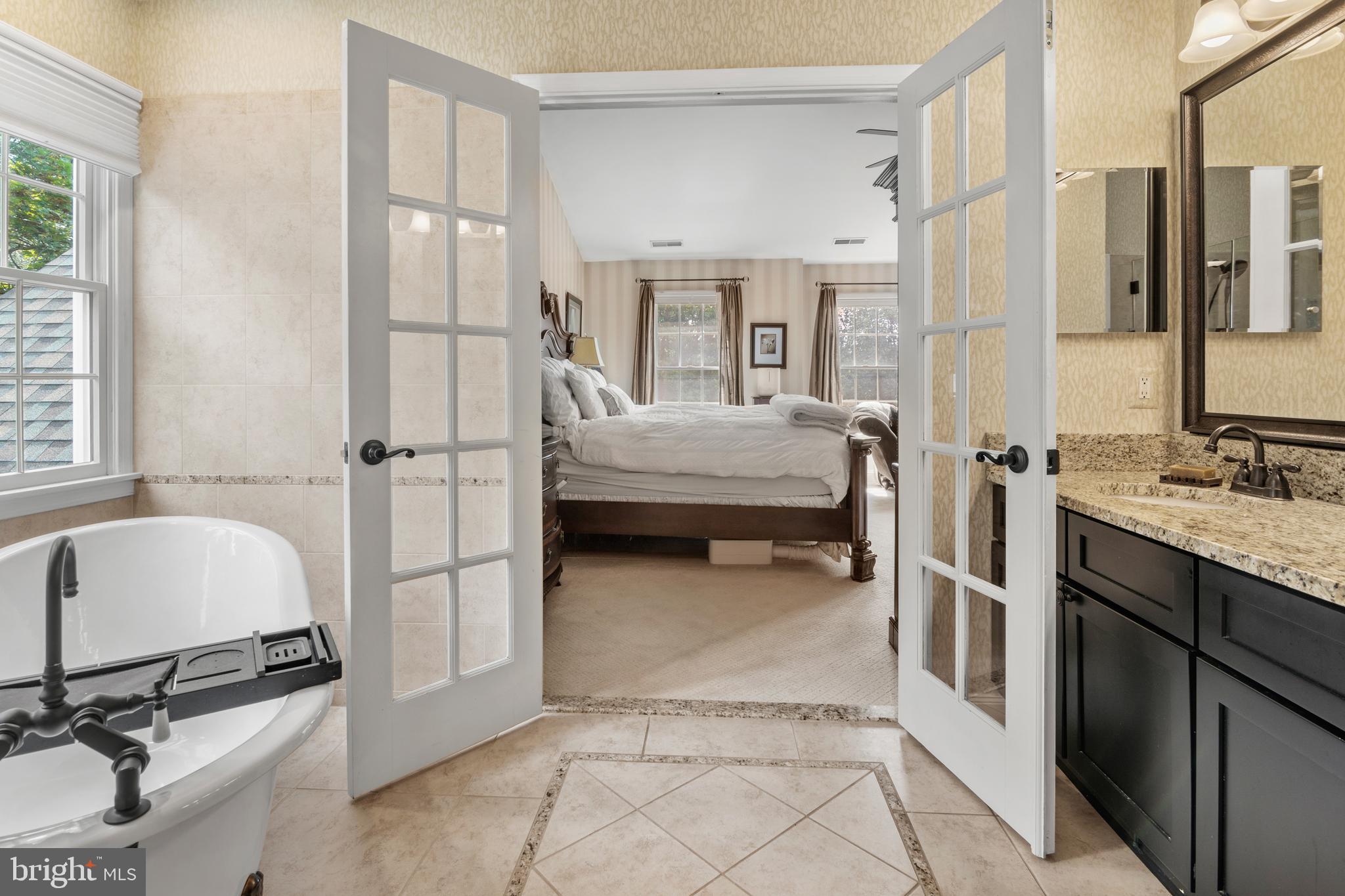 8504 Summershade Drive Odenton, MD 21113 - Photo 41 of 92 a en suite bathroom with a double vanity sink a mirror and a bathtub