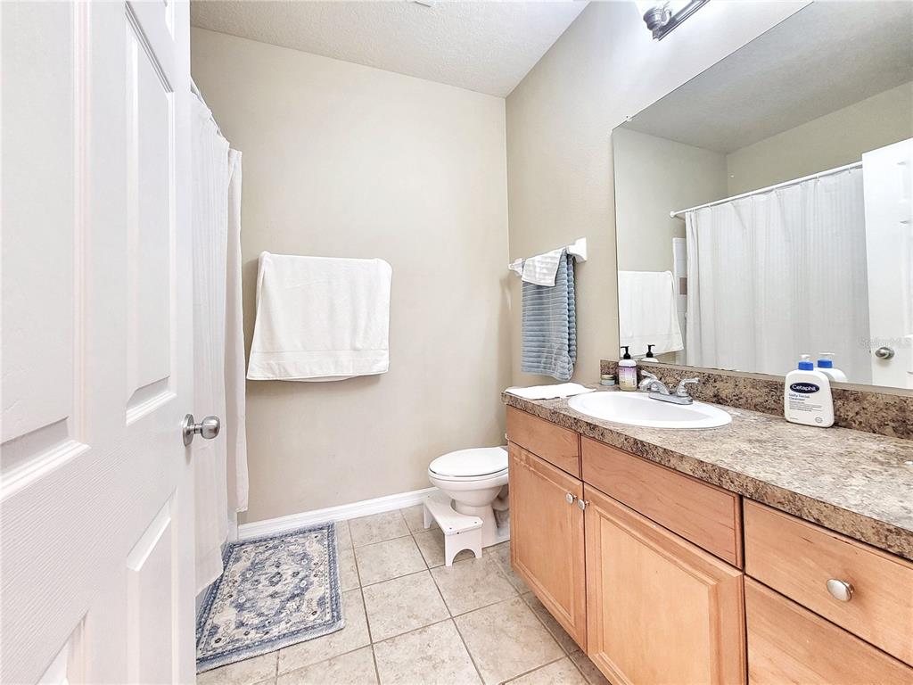 1185 Southwest 9th Road, Unit 306 Gainesville, FL 32601 - Photo 27 of 30 a bathroom with a granite countertop sink toilet and shower