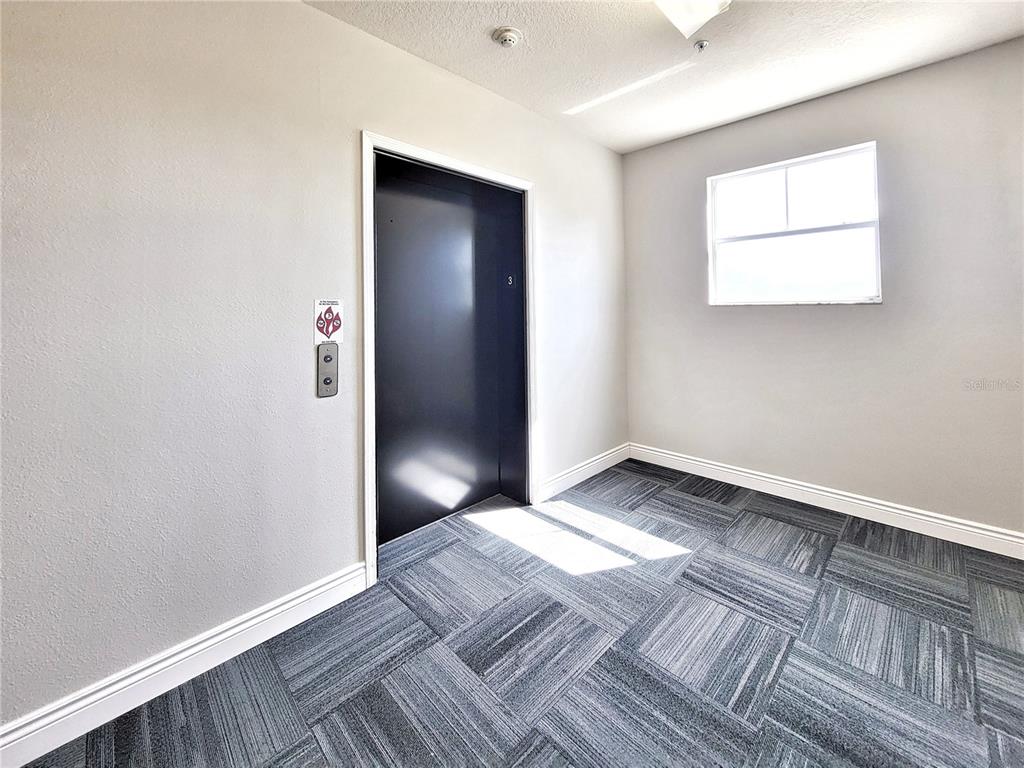 1185 Southwest 9th Road, Unit 306 Gainesville, FL 32601 - Photo 29 of 30 an empty room with wooden floor and windows